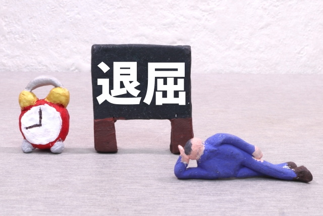 退屈の看板と寝そべる男性